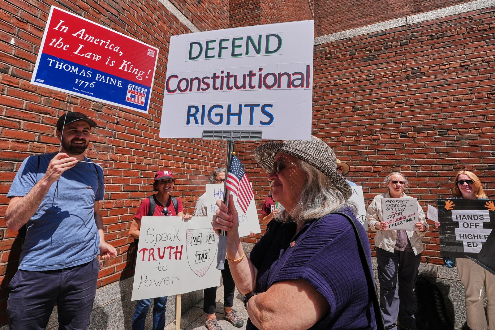 Protestors gather outside the Moakley Federal Courthouse, where Harvard University appeared to challenge $2.6 billion in funding cuts by the Trump administration, Monday, July 21, 2025, in Boston. (AP Photo/Charles Krupa)