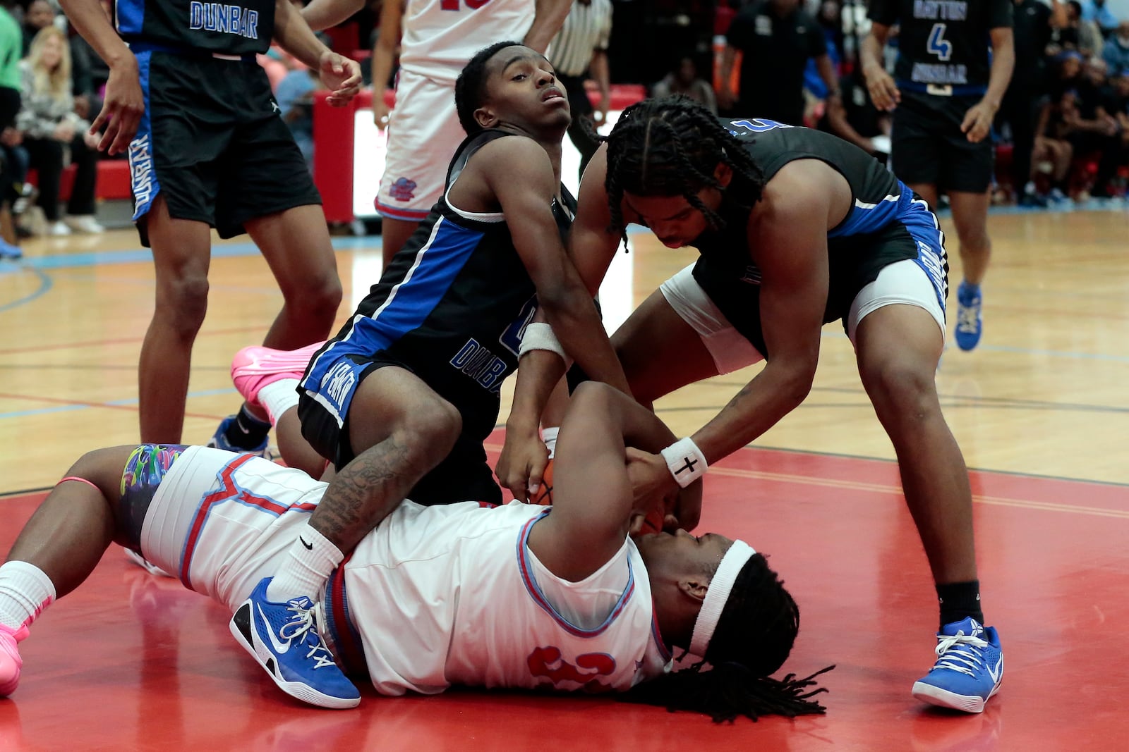 Several Dunbar and Belmont players try to gain possession of a loose ball. Dunbar defeated Belmont 55-40 in a Dayton City League boys basketball game on Feb., 10, 2026, at Belmont. STEVEN WRIGHT / STAFF