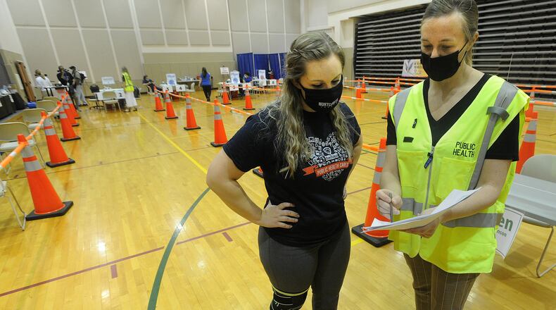 Emily (Warren) Tyler, left, and Jillian Botteicher, with the Dayton & Montgomery County Public Health, prepare for the COVID-19 vaccination clinic Wednesday, April 28, 2021 at the Sinclair College Centerville, located at 5800 Clyo Rd. MARSHALL GORBY\STAFF