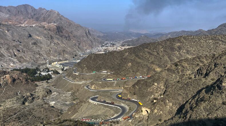 Smoke emits from Afghan side as trucks are parked along roadside following cross-border clashes between Pakistan and Afghan forces, at near Torkham border crossing point, Pakistan, Saturday, Feb. 28, 2026. (AP Photo/Maaz Awan)