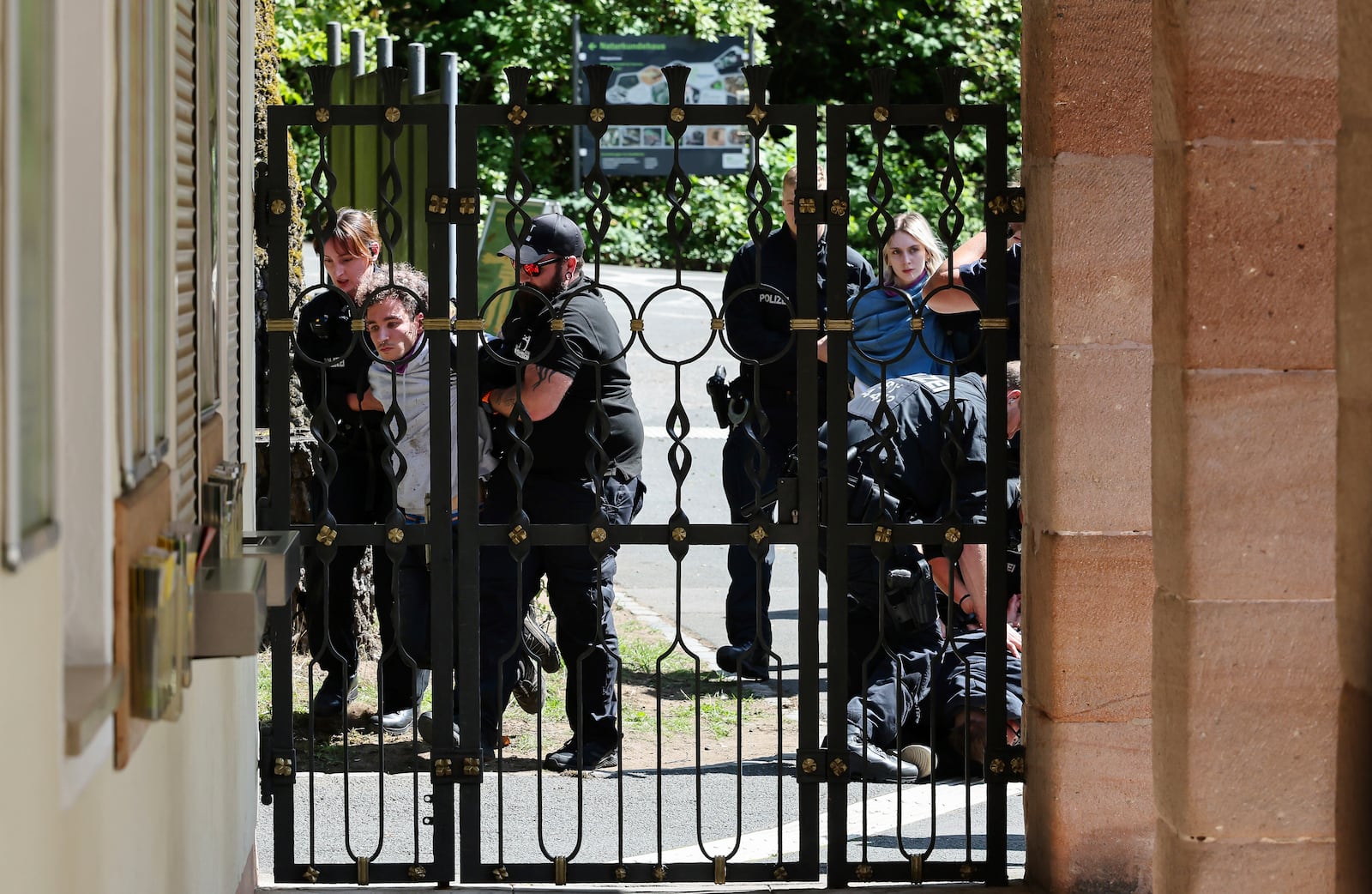Demonstrators from Animal Rebellion are arrested by the police after entering the grounds of the Nuremberg Zoo in Nuremberg, Germany, Tuesday, July 29, 2025. (Daniel Loeb/dpa via AP)