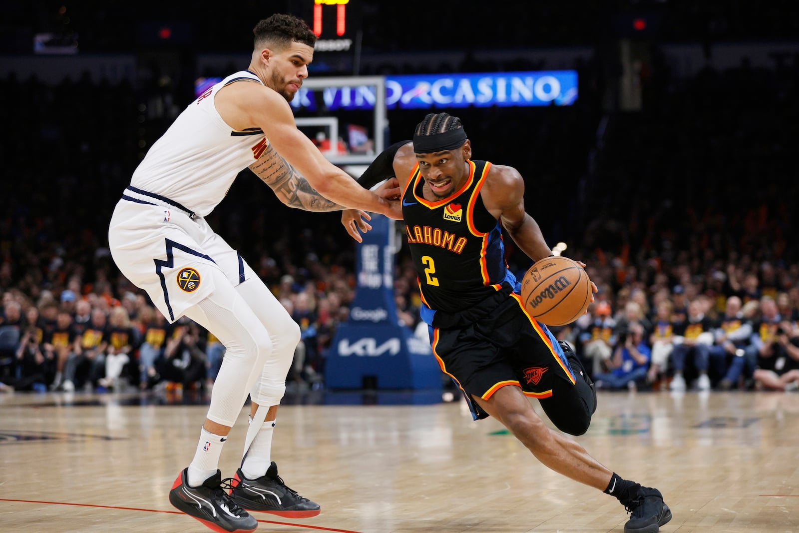 Oklahoma City Thunder guard Shai Gilgeous-Alexander (2) works to get past Denver Nuggets forward Michael Porter Jr., left, in the second half of Game 1 of an NBA basketball second-round playoff series Monday, May 5, 2025, in Oklahoma City. (AP Photo/Nate Billings)