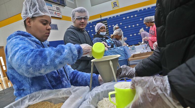 Springfield High School students put on hairnets and plastic gloves to package thousands of nutritious meals for the children of Lesotho in southern Africa Thursday, Oct. 6, 2022. This is the fourth year the high school has partnered with the Lesotho Nutrition Initiative to host the meal pack event. The children of Lesotho, one of the 30 poorest countries in the world, suffer from chronic malnutrition. BILL LACKEY/STAFF