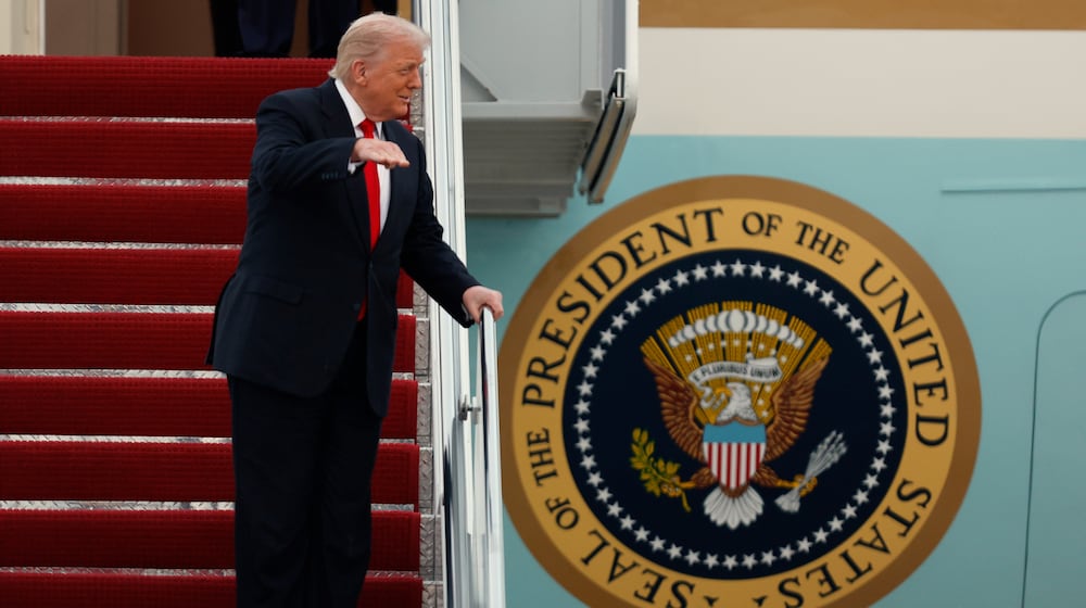 President Donald Trump gestures toward the media as he walks down the stairs of Air Force One upon his arrival at Joint Base Andrews, Md., Sunday, Nov. 9, 2025, after returning from his Mar-a-Lago estate in Palm Beach, Fla. and en route to an NFL football game between the Washington Commanders and the Detroit Lions. (AP Photo/Luis M. Alvarez)