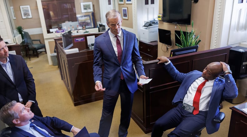 Senate Majority Leader John Thune R-S.D., center, privately speaks to Sen. Jon Husted, R-Ohio, and Sen. Tim Scott, R-S.C., ahead of a news conference on Capitol Hill on Saturday, March 21, 2026, in Washington. (AP Photo/Tom Brenner)