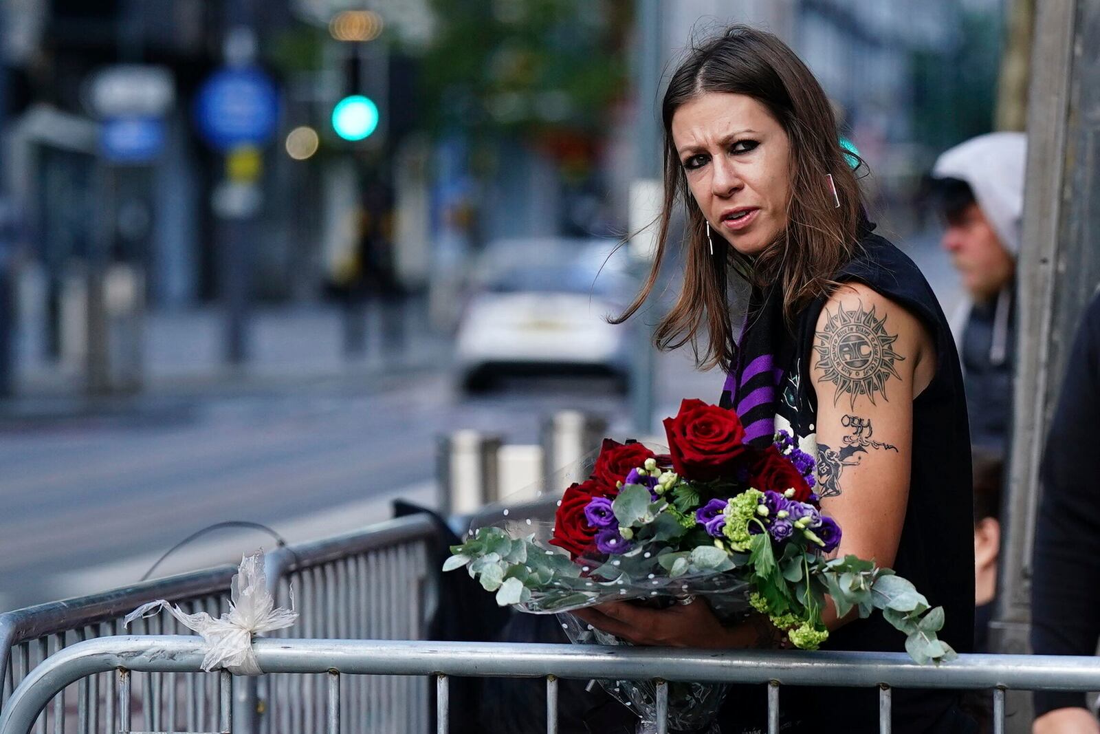 A fan waits near the Black Sabbath Bridge bench on Broad Street ahead of the funeral procession for Black Sabbath frontman Ozzy Osbourne, in Birmingham, England, Wednesday July 30, 2025. (Jacob King/PA via AP)