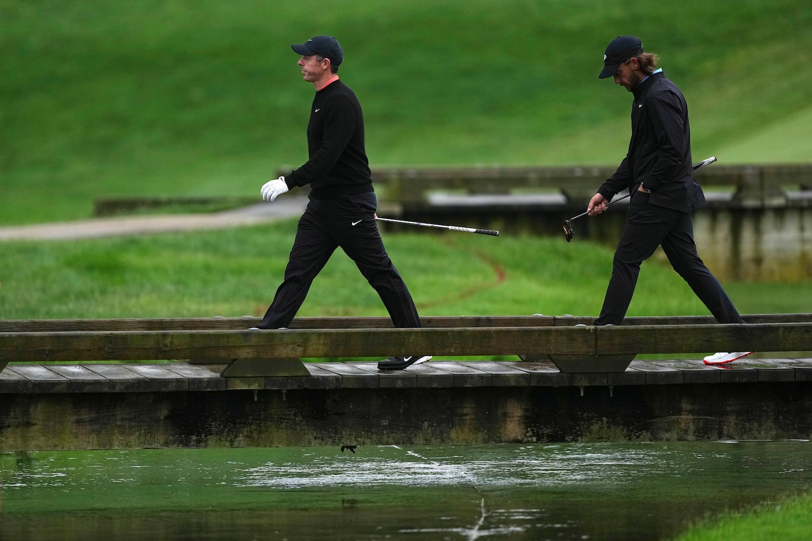 Rory McIlroy, left, of Northern Ireland, and Tommy Fleetwood, of England, walk on the 13th hole during the second round of the Truist Championship golf tournament at the Philadelphia Cricket Club, Friday, May 9, 2025, in Flourtown. (AP Photo/Matt Rourke)
