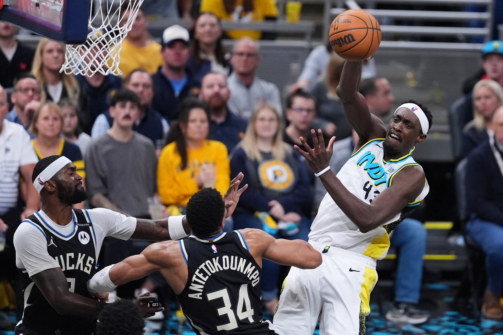 Indiana Pacers forward Pascal Siakam (43) makes a pass over Milwaukee Bucks forward Giannis Antetokounmpo (34) during the second half of a first-round NBA basketball playoff game in Indianapolis, Tuesday, April 22, 2025. (AP Photo/Michael Conroy)