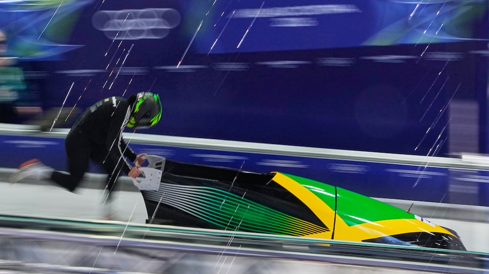 Jamaica's Mica Moore starts for a women's monobob training session at the 2026 Winter Olympics, in Cortina d'Ampezzo, Italy, Friday, Feb. 13, 2026. (AP Photo/Alessandra Tarantino)
