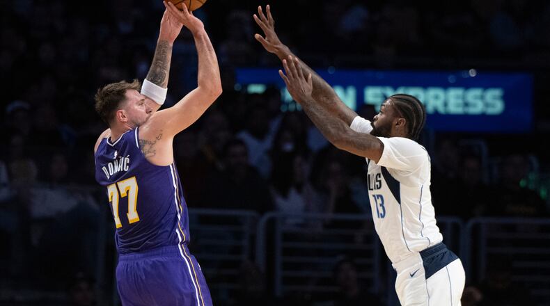 Los Angeles Lakers guard Luka Doncic (77) shoots as Dallas Mavericks forward Naji Marshall (13) defends during the first half of an NBA Cup basketball game in Los Angeles, Friday, Nov. 28, 2025. (AP Photo/Kyusung Gong)