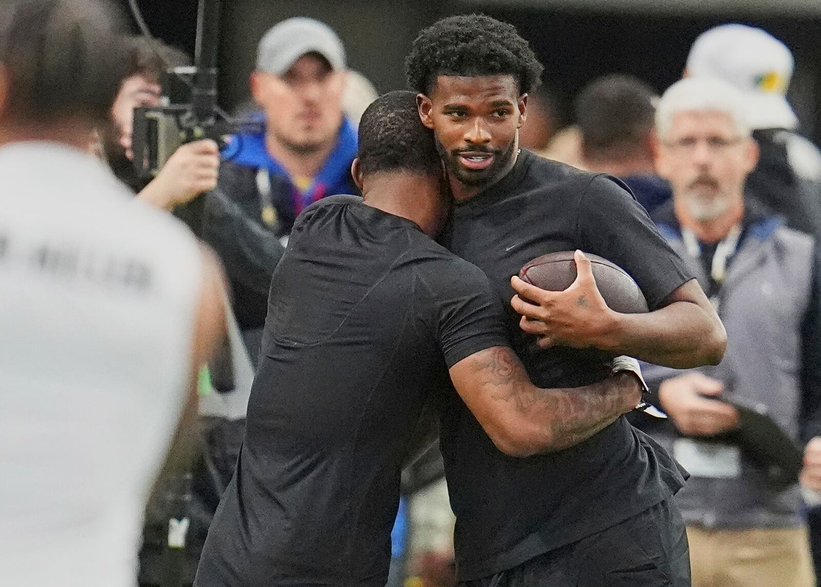 Colorado wide receiver LaJohntay Wester, left, hugs quarterback Shedeur Sanders before they take part in passing drills during Colorado's NFL football pro day Friday, April 4, 2025, in Boulder, Colo. (AP Photo/David Zalubowski)