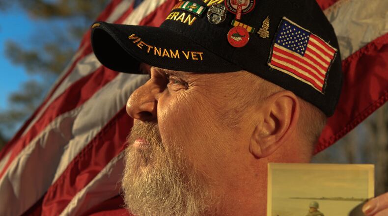 Holding a photo from one of his three tours of Vietnam, Bill Korber of Kettering is a 64-year-old veteran who has been fighting for 2.5 years with the VA Benefits Administration to be considered unemployable, which would increase his benefits. BIll has diabetes that was caused by his exposure to Agent Orange in Vietnam. Staff photo by Jim Witmer