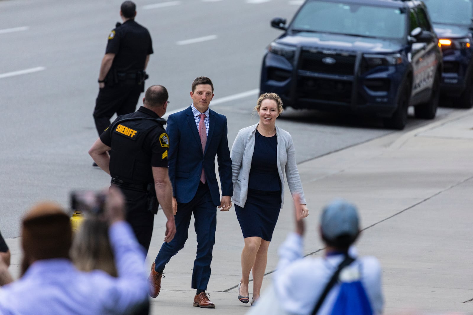Former Grand Rapids Police officer Christopher Schurr and his wife Brandey are cheered on by supporters as they enter the Kent County Courthouse in Grand Rapids, Mich. on Friday, May 2, 2025. (Joel Bissell /Kalamazoo Gazette via AP)