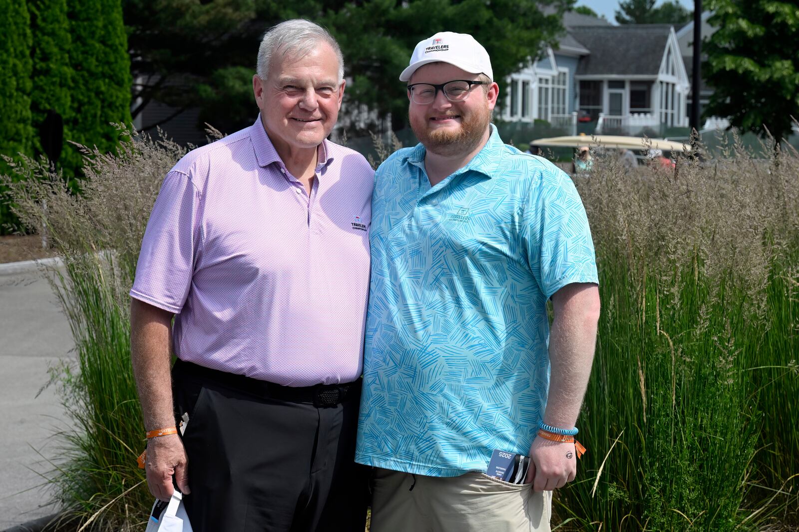 Andy Bessette, left, executive vice president and chief administrative officer for Travelers, and his son Chris Bessette, right, smile during the Travelers Championship golf tournament at TPC River Highlands in Cromwell, Conn., Thursday, June 19, 2025. (AP Photo/Jessica Hill)