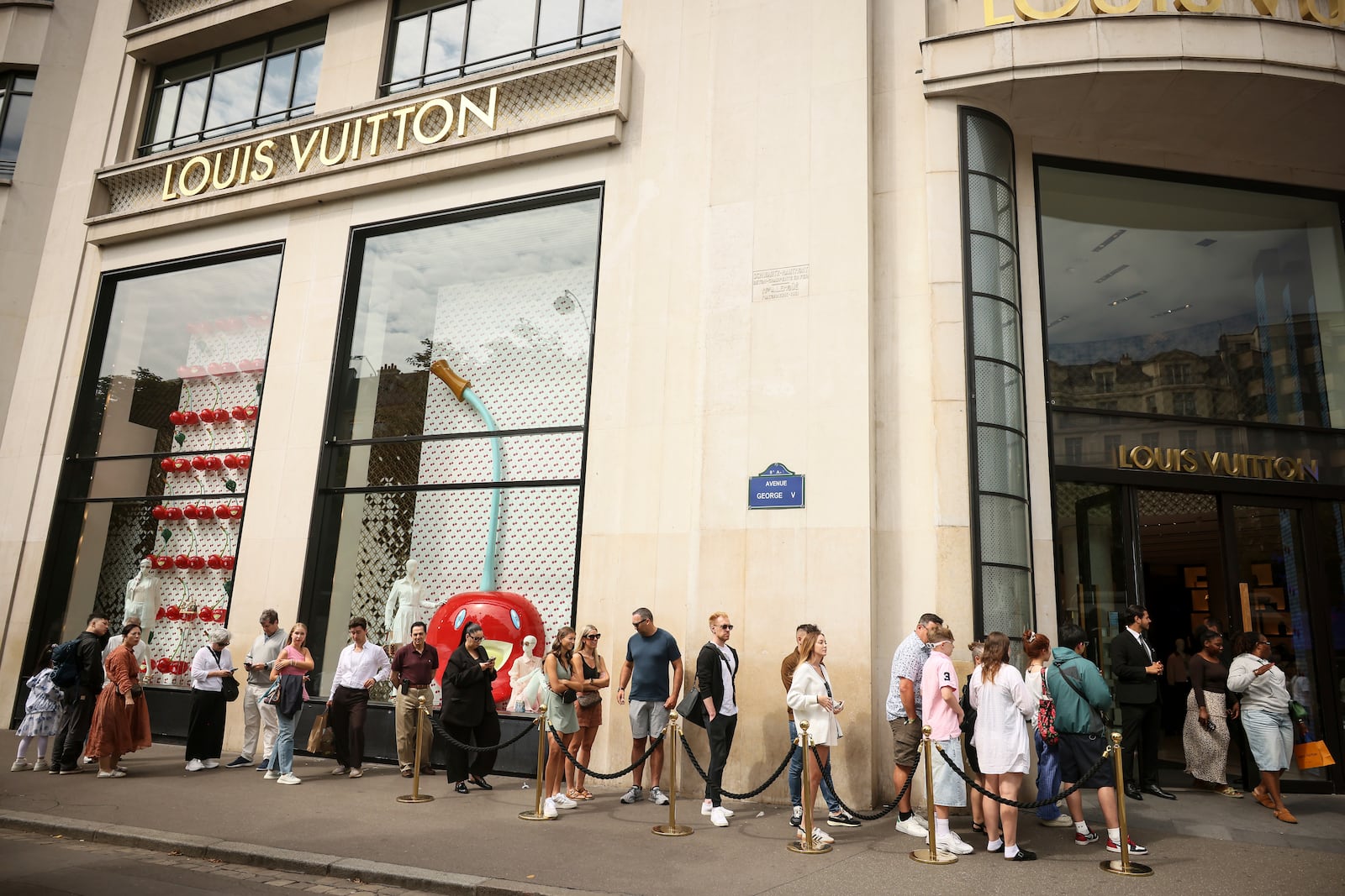 People queue outside the Louis Vuitton store, Monday, July 28, 2025 in Paris. (AP Photo/Thomas Padilla)