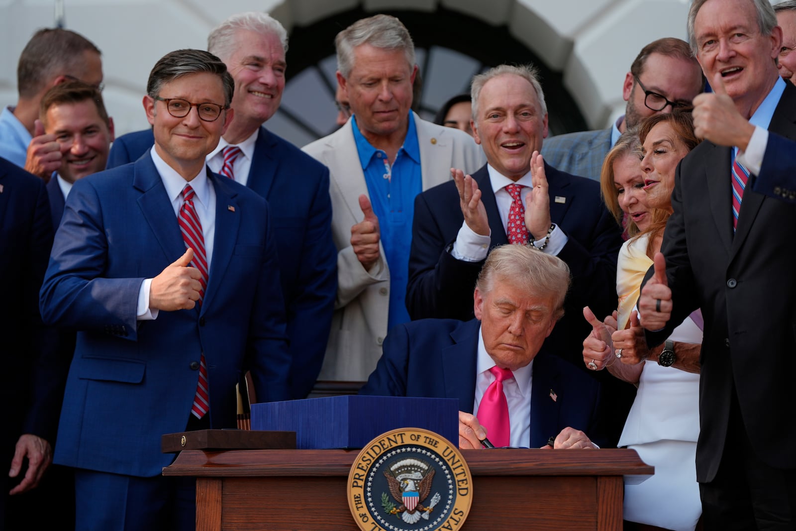 FILE - President Donald Trump signs his signature bill of tax breaks and spending cuts at the White House, July 4, 2025, in Washington, surrounded by members of Congress. (AP Photo/Julia Demaree Nikhinson)