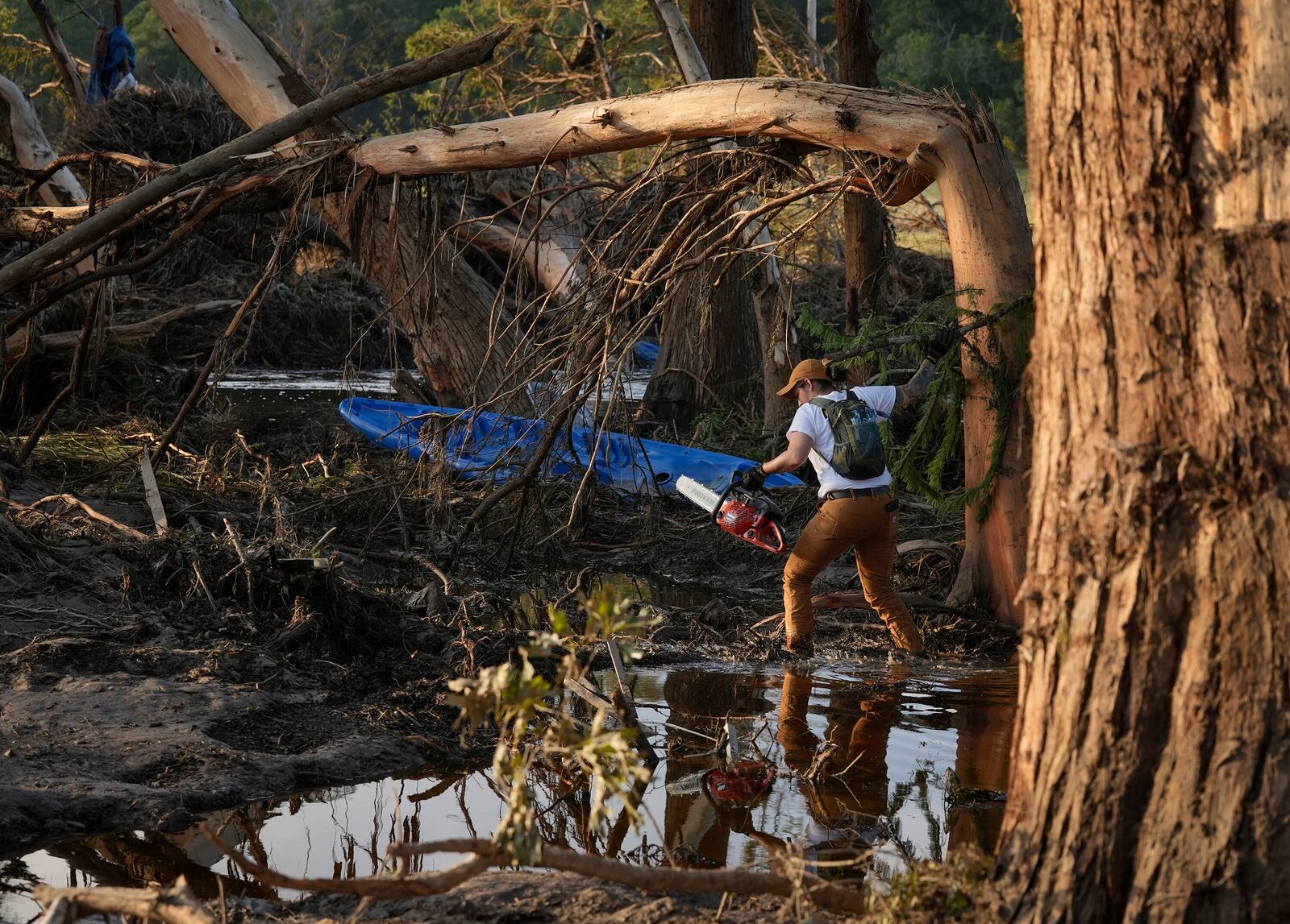 Miranda Gonzales, a volunteer with Heroes for Humanity, does search and recovery work on the banks of the Guadalupe River in Ingram, Texas, Tuesday, July 8, 2025, after the Fourth of July flood. (Jay Janner/Austin American-Statesman via AP)