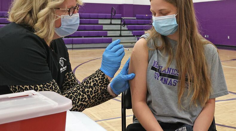 Mechanicsburg student Lily Eck, who just turned 16 two days earlier, gets the COVID vaccine from Hope Stickley, a nurse from the Champaign County Health Department, during a COVID clinic in one of the Mechanicsburg gymnasiums. BILL LACKEY/STAFF