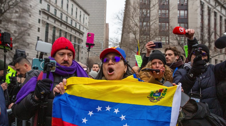 A demonstrator with a Venezuelan flag outside the federal courthouse in lower Manhattan, where Nicolas Maduro, the ousted president of Venezuela, and his wife, Cilia Florez, are scheduled to be arraigned later on Monday, Jan. 5, 2026. Maduro and Flores are expected to face charges of drug trafficking and other crimes, two days after they were captured in a U.S. military raid in Caracas. (Sara Hylton/The New York Times)