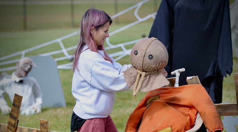 Debbie Knisely gets into the Halloween spirit decorating her front yard on New Carlisle Pike Friday, October 7, 2022.