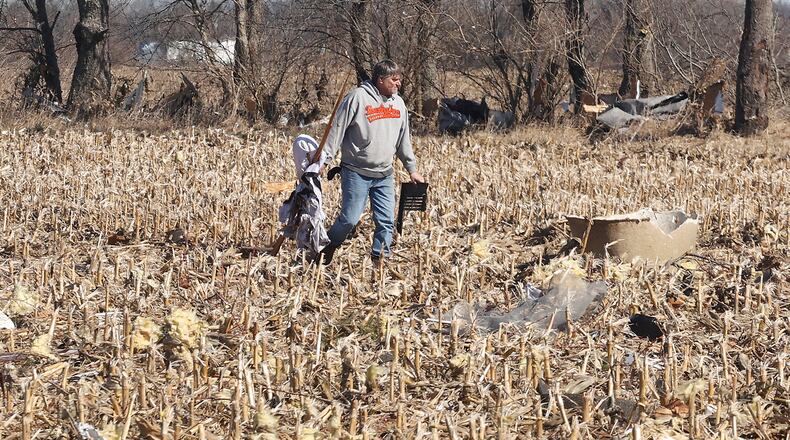 Kevin Martin picks up parts of his son's house that were blown into a corn field Thursday, Feb. 29, 2024 as he helps him clean up after Wednesday's tornado. BILL LACKEY/STAFF