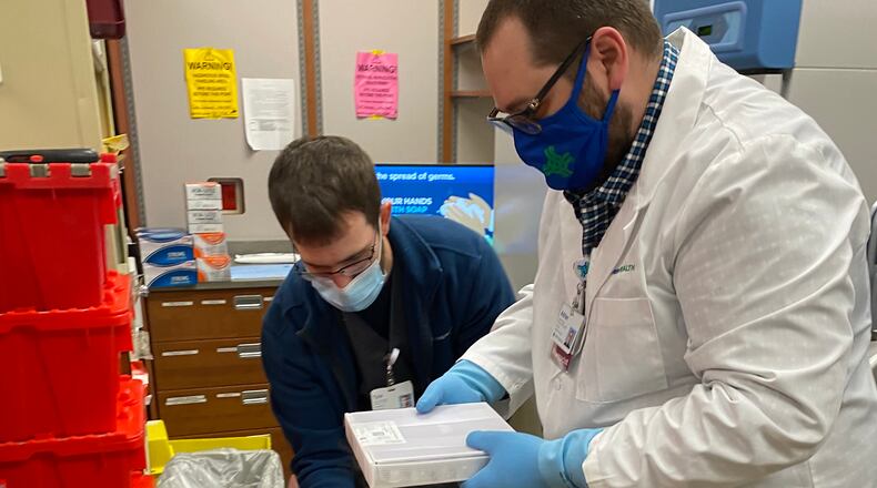 Two Springfield Regional Medical Center employees handle their shipment of the Pfizer COVID-19 vaccine on Tuesday, Dec. 15, 2020. Staff vaccinated last month will begin receiving their second dose of the vaccine this week. Contributed