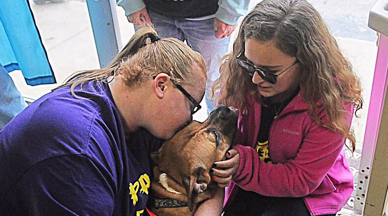 Heather Dean, left, and Olivia Fife, gives hugs and kisses to one of the rescue dogs at the Pawsitive Warriors Rescue In New Carlisle last week. Marshall Gorby/STAFF