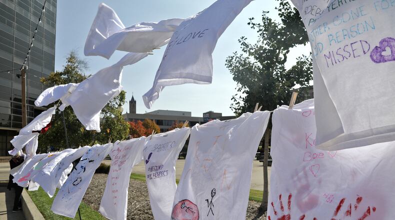 Clotheslines full of T-shirts with messages on them hang on the Springfield City Hall Plaza Friday, Oct. 14, 2022. The T-shirts are part of the Clothesline Project, which allows victims of violent crime to express their feelings in an anonymous way by writing or drawing on the T-shirts. This year's project is starting with 160 T-shirts but people are welcome to come down Friday till 7pm and Saturday from 9am till 7pm and create their own T-shirt message. BILL LACKEY/STAFF
