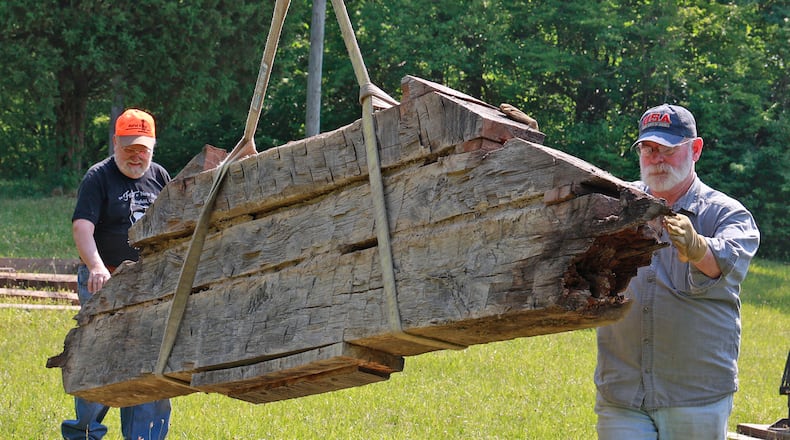 Jim Campbell (left) and Aaron Davis guide a section of the wall that made up the log cabin at George Rogers Clark Park into place Friday, June 9, 2023. The cabin, which was built in 1974, is being disassembled to repair some of the damage caused by decades of exposure to the weather. Jim Campbell was part of the crew that built the cabin nearly 50 years ago. BILL LACKEY/STAFF