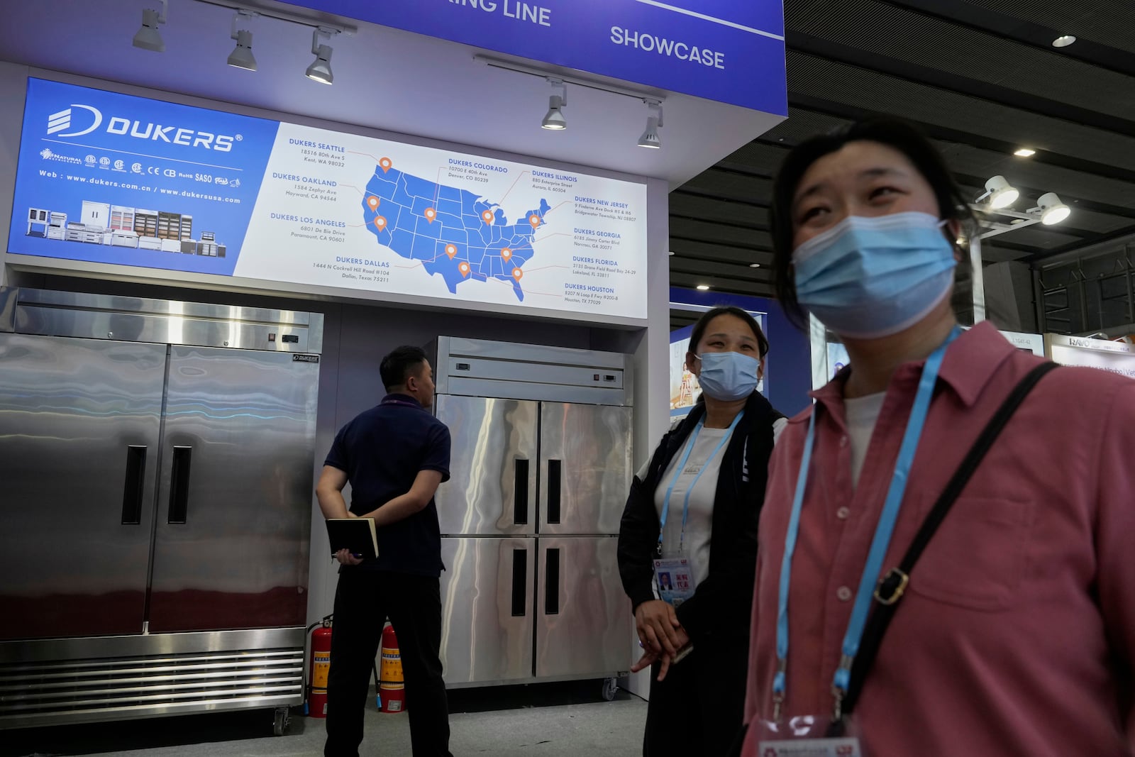 FILE - Visitors past by a map of the United States offices for Dukers, a manufacturer of refrigeration and cooking equipment, at the 137th Canton Fair, in Guangzhou in southern China's Guangdong province on April 15, 2025. (AP Photo/Ng Han Guan, File)