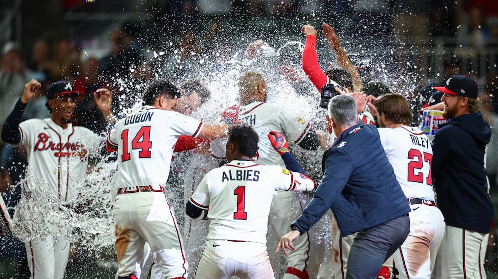 The Atlanta Braves celebrate at home plate after a walkoff grand slam from Dominic Smith, center, in the ninth inning of a baseball game against the Kansas City Royals, Saturday, March 28, 2026, in Atlanta. (AP Photo/Colin Hubbard)