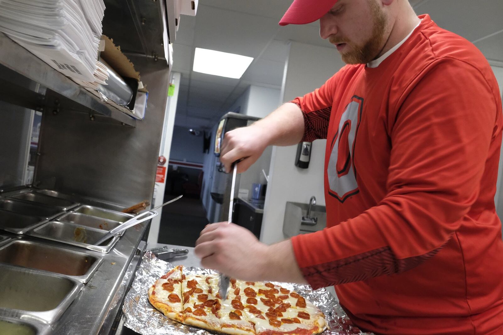 Nick Hanaway cuts a customers pizza in the kitchen at The Barn Thursday. A local favorite, The Barn is back in business after closing down last year. Bill Lackey/Staff