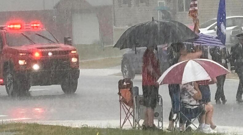 Spectators watch the 2024 Enon Independence Day Parade in the rain Thursday, July 4, 2024. Photo by Denise Bockleman.