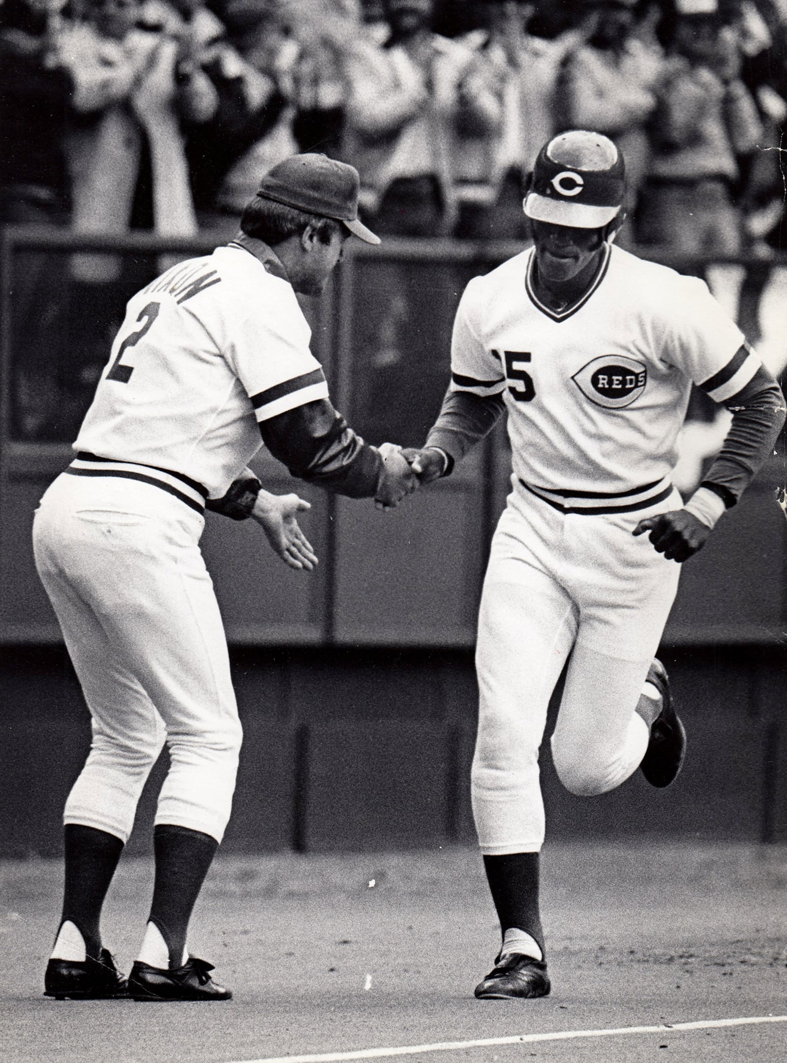 Cincinnati Reds third base coach Russ Nixon congratulates George Foster on a home run during the 1980 opening day game. DAYTON DAILY NEWS ARCHIVE