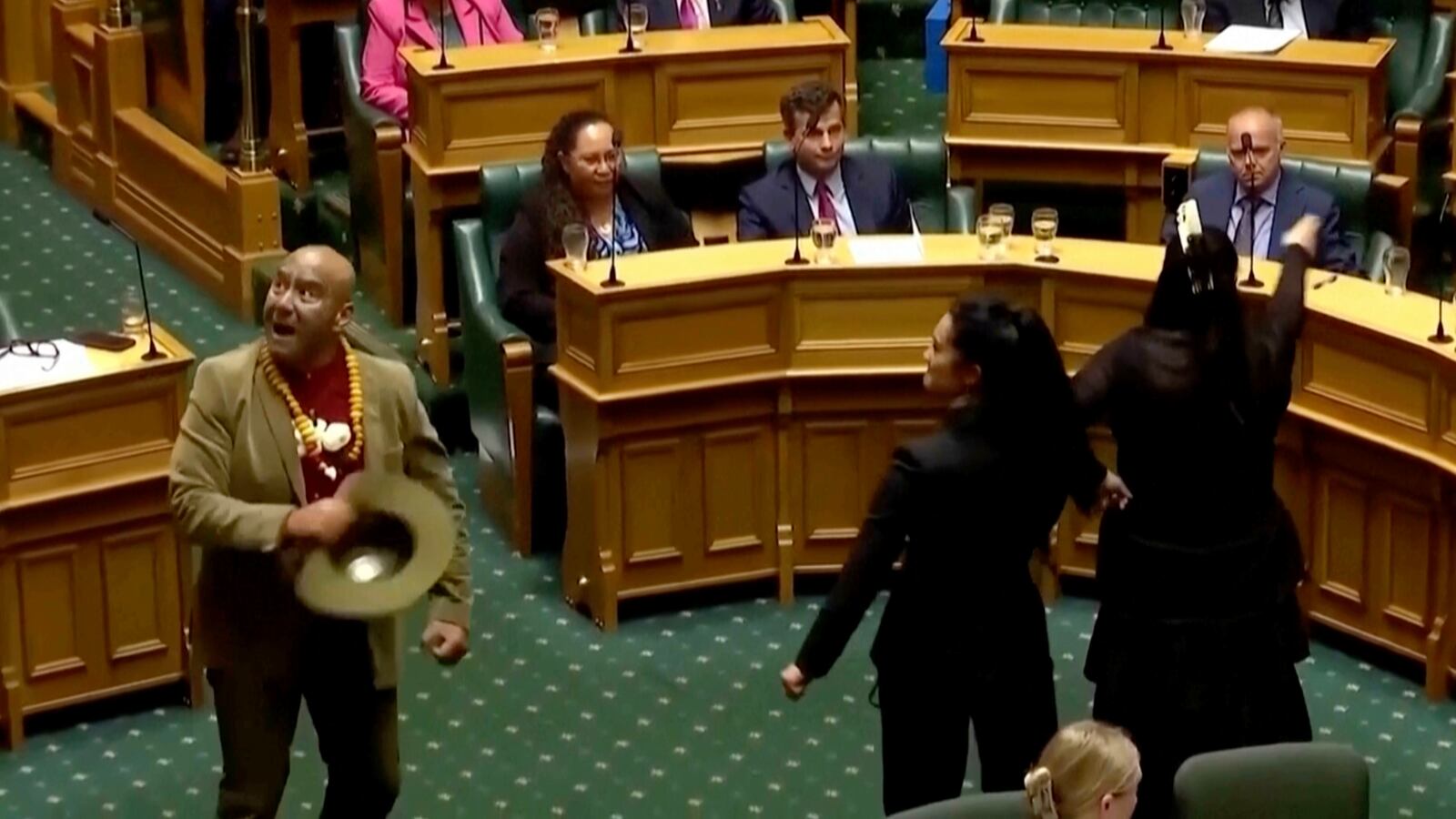 In this image from video provided by New Zealand Parliament TV, lawmakers, from foreground left, Rawiri Waititi, Hana-Rāwhiti Maipi-Clarke and Debbie Ngarewa-Packer perform a Māori haka to protest a proposed law during a session of Parliament in Wellington, New Zealand, on Nov. 14, 2024, (New Zealand Parliament TV via AP)