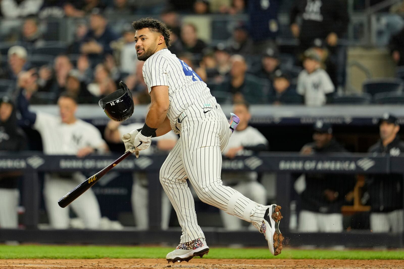 New York Yankees' Jasson Domínguez helmet falls off as he hits a three-run double during the sixth inning of a baseball game Kansas City Royals Tuesday, April 15, 2025, in New York. All the players are wearing 42 in honor of Jackie Robinson Day. (AP Photo/Seth Wenig)