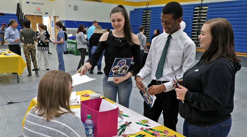 Heaven Kuhn, left, a senior at Springfield High School, hands her resume to Lynette Newton, from The Ohio Masonic Community, as Kuhn and fellow seniors Fred Almon and Madison Brown talk to Newton about employment opportunities at the school’s second annual Career Fair in April. More than 20 local employers were on hand to talk with over 150 students about career opportunities locally. BILL LACKEY/STAFF