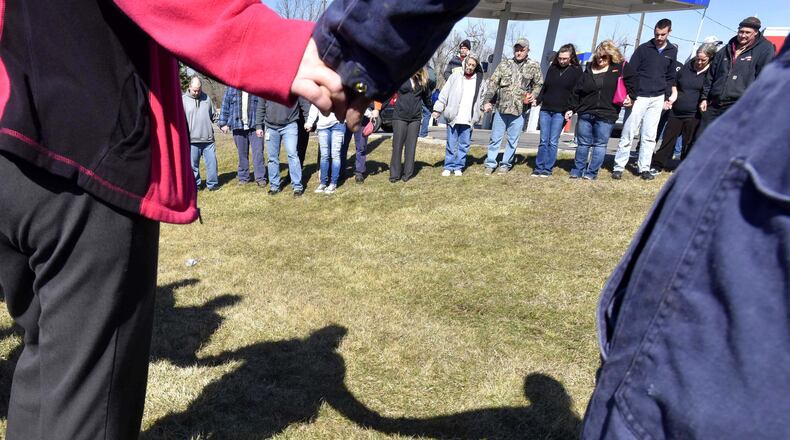 Parents and community members form a prayer circle after a 2016 shooting at Madison Jr./Sr. High School in Butler County. STAFF FILE/2016