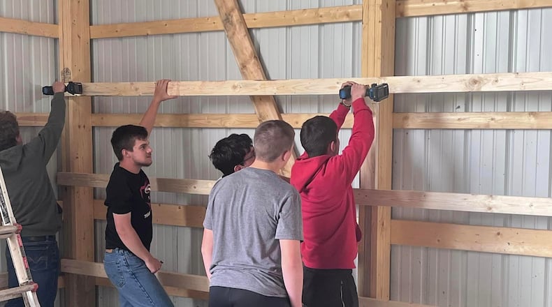 Students doing some of the work on Triad Local School District’s new agricultural FFA barn. Contributed