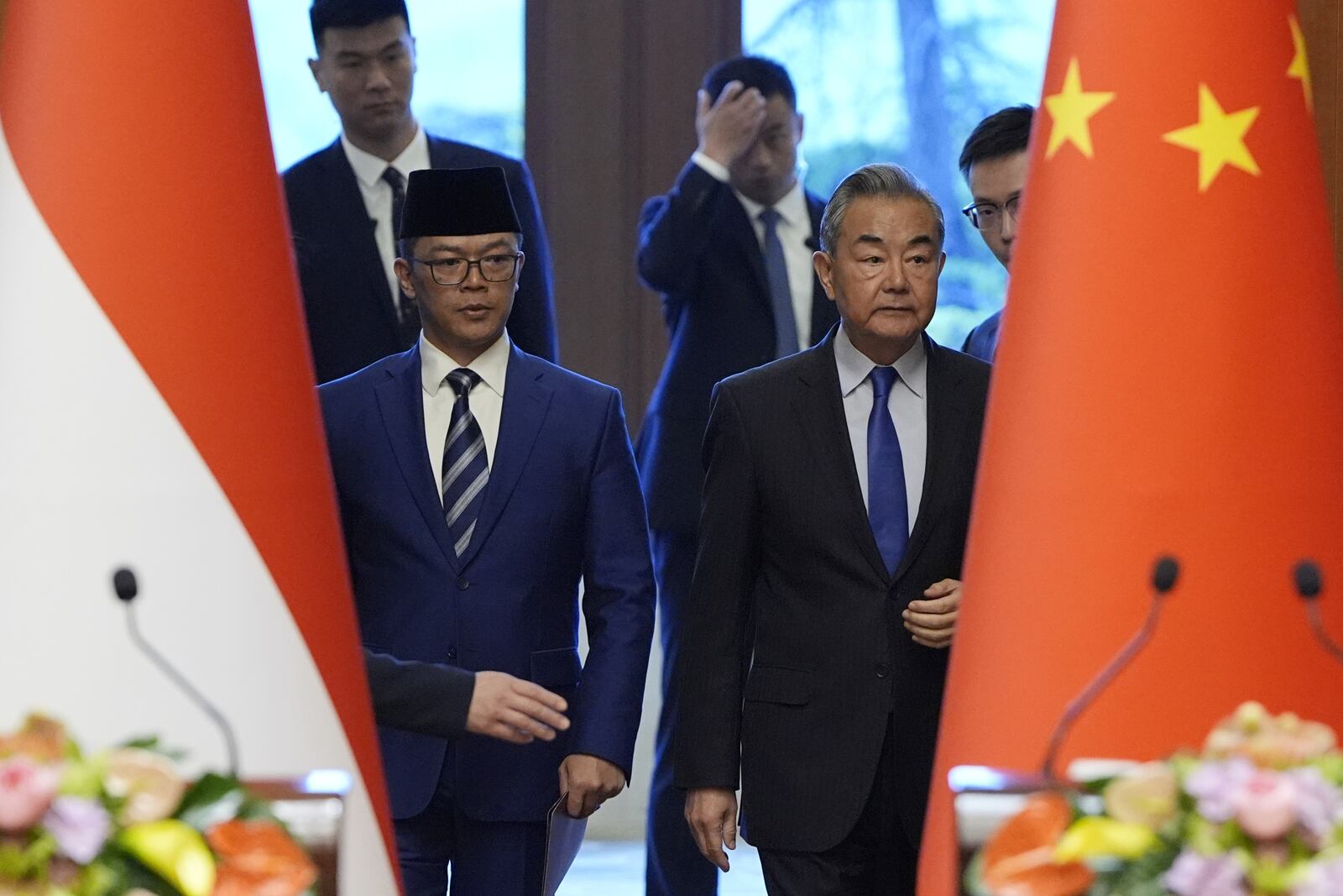 Indonesian Foreign Minister Sugiono, front left, and Chinese Foreign Minister Wang Yi, front right, arrive for a press briefing about the first meeting of China-Indonesia joint foreign and defense ministerial dialogue at the Diaoyutai State Guest House in Beijing Monday, April 21, 2025. (Iori Sagisawa/Pool Photo via AP)