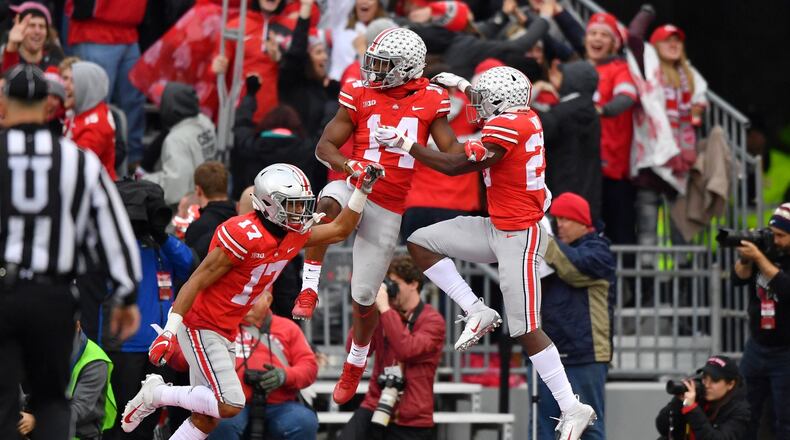 Chris Olave #17, K.J. Hill #14 and Jahsen Wint #23 of the Ohio State Buckeyes, celebrate after Olave blocked a Michigan Wolverines punt in the third quarter and Ohio State scored a touchdown at Ohio Stadium on November 24, 2018 in Columbus, Ohio. Ohio State defeated Michigan 62-39. (Photo by Jamie Sabau/Getty Images)