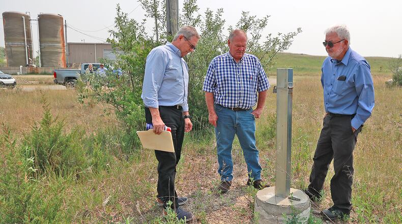 Bob Rule (left), from the potentially responsible party group, German Twp. trustee Rodney Kaffenbarger (center), and Larry Ricketts, from the People for Safe Water group, look over a testing well for the Tremont City Barrel Fill on Wednesday, June 7, 2023. BILL LACKEY/STAFF