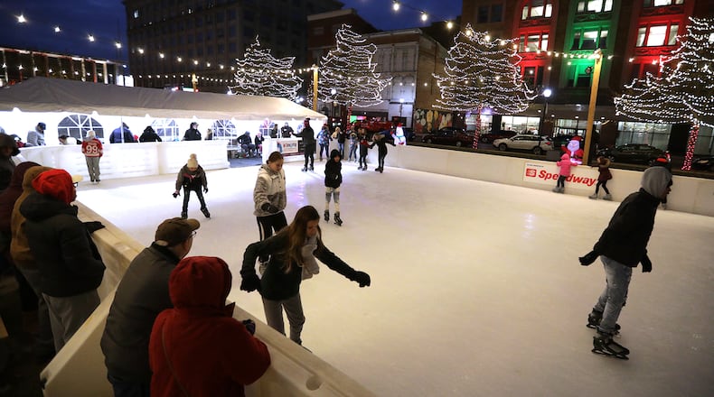 Skaters slide across the ice, some fast and others a bit slower, on the new outdoor ice skating rink Friday night during the Grand Illumination in downtown Springfield. BILL LACKEY/STAFF