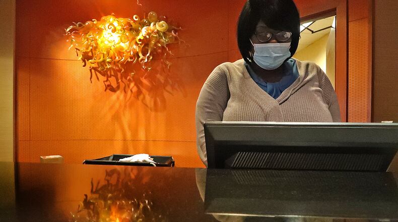 Jazzmin Shine, an employee of the Courtyard by Marriott hotel in downtown Springfield, makes a reservation for a guest Tuesday. BILL LACKEY/STAFF