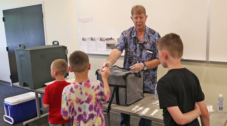 Springfield and Urbana City School Districts, along with the Mechanicsburg Public Library, will offer summer meals to kids. In this file photo, Don Rumpff, from the Clark County Library, passed out food during the Summer Food Program a few years ago at the library's main branch. FILE/BILL LACKEY/STAFF