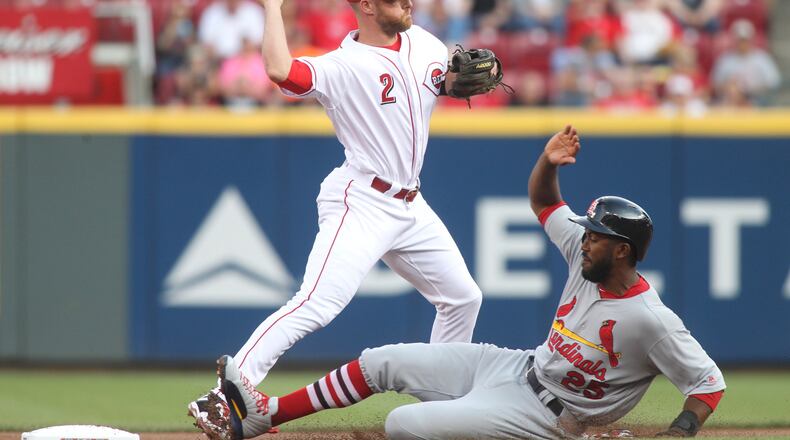 Reds shortstop Zack Cozart turns a double play as the Cardinals’ Dexter Fowler slides into second base on Monday, June 5, 2017, at Great American Ball Park in Cincinnati. David Jablonski/Staff