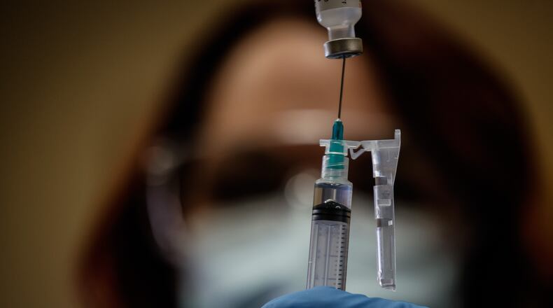 Jacinda Snider, a collaborative pharmacist distributes COVID-19 booster shots at Grafton Oaks Nursing Home on Grafton Ave. Tuesday Jan. 11, 2022. Snider volunteers long hours including evenings and weekends to give people vaccines. She has provided hundreds of Ohioans against COVID-19. JIM NOELKER/STAFF