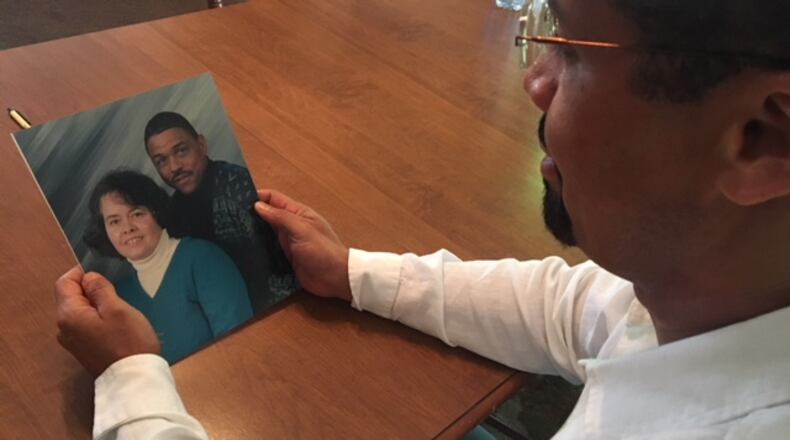 Kelley Edley holds a picture of his late parents. His father, Howard Edley, was shot and killed in Springfield recently. STAFF PHOTO JENNA LAWSON
