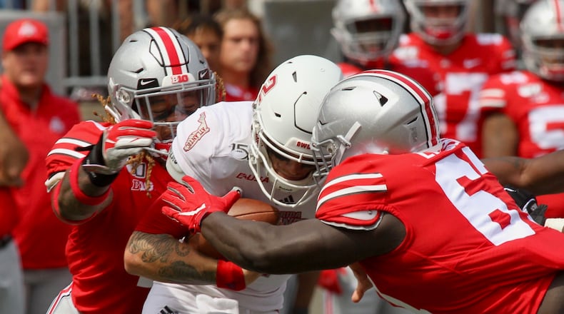 Ohio State’s Robert Landers, right, and Chase Young, left, sack Florida Atlantic quarterback Chris Robinson on Saturday, Aug. 31, 2019, at Ohio Stadium in Columbus. David Jablonski/Staff