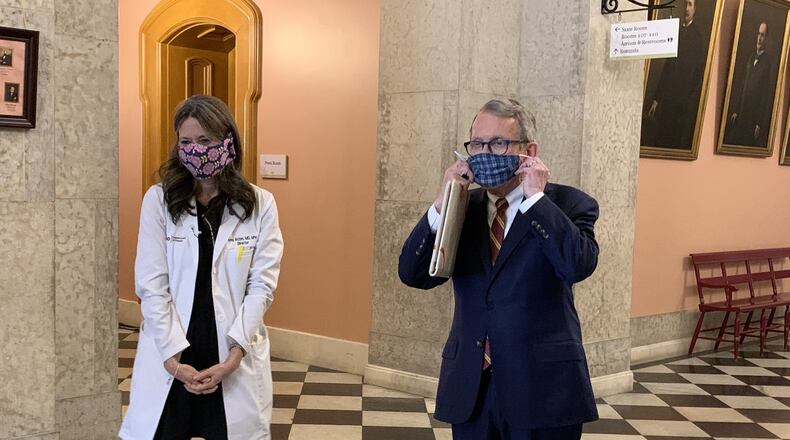 Ohio Gov. Mike DeWine and Ohio Health Department Director Dr. Amy Acton show off home-made protective masks at the Ohio Statehouse on Monday. Photo by Laura A Bischoff. Columbus bureau
